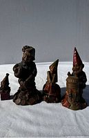 Photo of four Tom Clark gnome figurines set in a row showing details and relative sizes