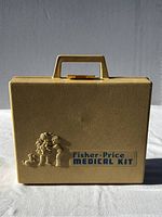 Closed beige plastic Fisher-Price medical kit case with embossed child characters and company logo on front.