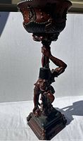 Front view of the full planter showing the monkey figure holding the decorated planter bowl.