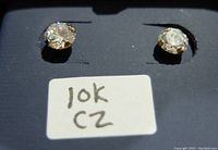 Close-up photo of pair of round cubic zirconia stud earrings set in 10K gold.