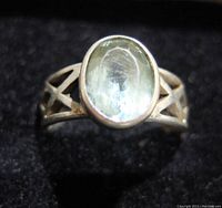 Close up photo of the oval cabochon blue topaz set in a .925 silver detailed band