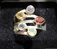 Front view of multi gemstone sterling silver ring showing five different colored stones: purple, yellow, red, blue, and green.