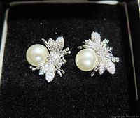 Close-up front view of the pair of honey bee fashion earrings showing rhinestone wings and pearl body set in silver-tone metal.