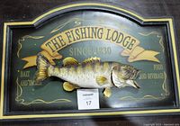 Full view of the wall hanging showing the fish mounted on a wooden plaque and text 'The Fishing Lodge Since 1830 Bait and Tackle Food and Beverage'