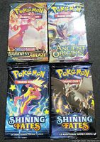 Front view of four sealed Pokémon TCG booster packs showing different series and artwork.