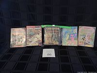 Photo showing 6 vintage Big Little Books including Flash Gordon, Space Ghost, Pink Panther, Mickey Mouse, and others arranged standing upright.