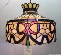 Front view showing the stained glass lamp with pink ribbon pattern and crown-like top design.