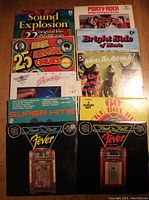 Top-down view of all ten vinyl record covers showing colorful variety of rock and roll themed compilation albums.