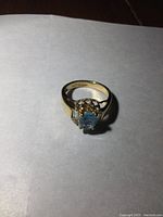 Top view showing oval light blue center gemstone and two baguette-cut clear stones