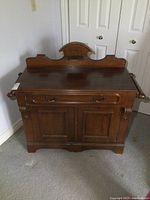Front view showing entire washstand with backsplash, drawer and cabinet below