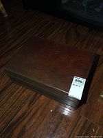 Closed wood chest with smooth finish and visible wood grain.