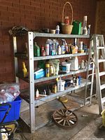 Full view of the heavy-duty metal shelf unit filled with various garage items like containers, cans, and bottles of cleaners and chemicals.