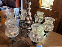 Overall view of chandelier with six attached glass globes on a wooden table
