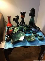 All assorted Blue Mountain Pottery items displayed on table, including vases, figurines, bowls, cream and sugar pieces