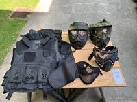 Photo showing all protective items: 3 face guards, 2 tactical vests, 1 nose and mouth guard.