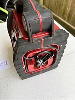 Close-up of bottom side showing battery jumper clamps stored in compartment recessed within rugged rubber base