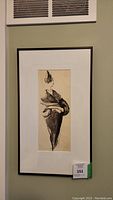 Full view of framed ink artwork hanging on a wall.