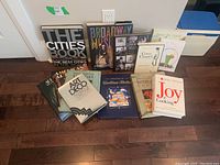 All eleven coffee table books arranged in two rows on hardwood floor