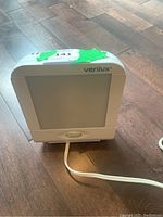 Front view of the Verilux S.A.D. Light therapy lamp placed on a wooden floor showing the light panel and power cord.