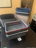 Stack of assorted plastic storage baskets including small, medium, and large sizes in beige, black, and grey colors.