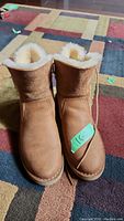 Front view of both brown UGG boots size 6.5 with visible shearling lining and clean leather exterior.