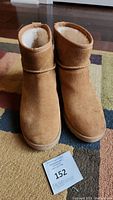 Front view of the UGG brown wedge heel boots showing the suede texture and plush lining.