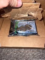 Top view of the Seagate Barracuda hard drive still sealed in anti-static bag inside the open cardboard box.