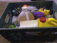 Overview of crate showing all cleaning supplies including bottles, containers, and cloths