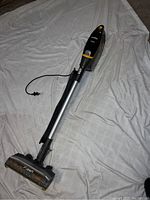 Full view of the Eureka vacuum cleaner showing its stick and motor unit with power cord attached.