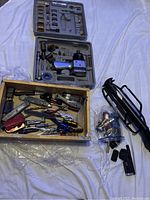 Power drill in carrying case with multiple drill bits and accessories, alongside an open drawer of assorted hand tools