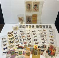 Full collection laid out showing cards and silks arranged separately, butterfly card rows, flower cards, historic figure cards, and embroidered silk patches visible.
