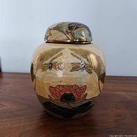Front view of vintage brass cloisonné enameled ginger jar with floral designs in enamel and brass finish