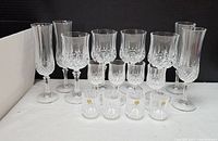 Full set of 16 lead crystal glasses showing 4 champagne, 4 wine, 4 liquor, and 4 shot glasses with detailed faceted cuts and clear crystal finish.