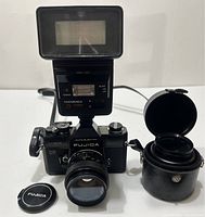 Fujica ST901 camera with mounted Fujinon 55mm f/1.8 lens, Hanimex TZ855 flash mounted on camera hot shoe, Fujica lens cap, and lens case.
