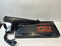Sega Master System 1 console with Light Phaser gun controller connected and coiled cable visible.