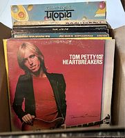 Box of various vinyl LP albums with Tom Petty and the Heartbreakers featured prominently on top.