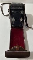 Front view of Yashica-D camera from above with case open showing front body and nameplate