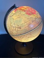 Globe illuminated showing North America with visible geographic names and some wear along the seam.
