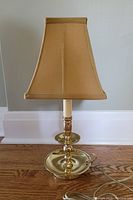 Full lamp with fabric shade, showing brass base, finger loop, candlestick design, and socket with candle sleeve.