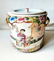 Front view of the jar showing a seated woman in traditional Chinese costume with floral and nature-themed decorations around her, gold handles on the sides.