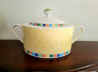 Side view of the yellow tureen dish showing multicolor square border and handles.