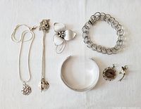 Top view of the jewelry lot showing all pieces laid out on fabric background, including necklaces, bracelets, brooch, and earrings.