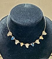 Front view of the Jakob Bengel Art Deco necklace displayed on a black mannequin bust, showing the silver-tone metal chain and blue and cream Galalith rectangular geometric links in a modernist style.
