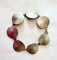 Top view of the bracelet showing textured radiating starburst pattern on multiple linked discs.