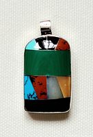 Front view of pendant showing multicolored turquoise, red, cream, and black inlays