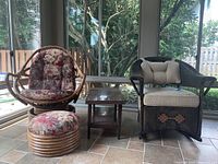 Photo showing the two chairs, ottoman, and side table in enclosed porch area with windows and tiled floor.