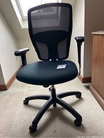 Front and side view of black office chair with mesh backrest, cushioned seat, armrests, and five caster wheels on base.