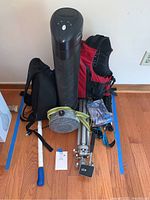 Full view of lot items placed on wooden floor, showing all included outdoor gear and air purifier.