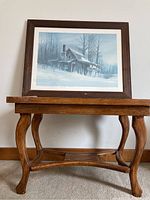 Framed print on wooden solid end table showing full height and structure.