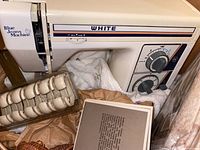 White Blue Jeans sewing machine shown with sewing accessories